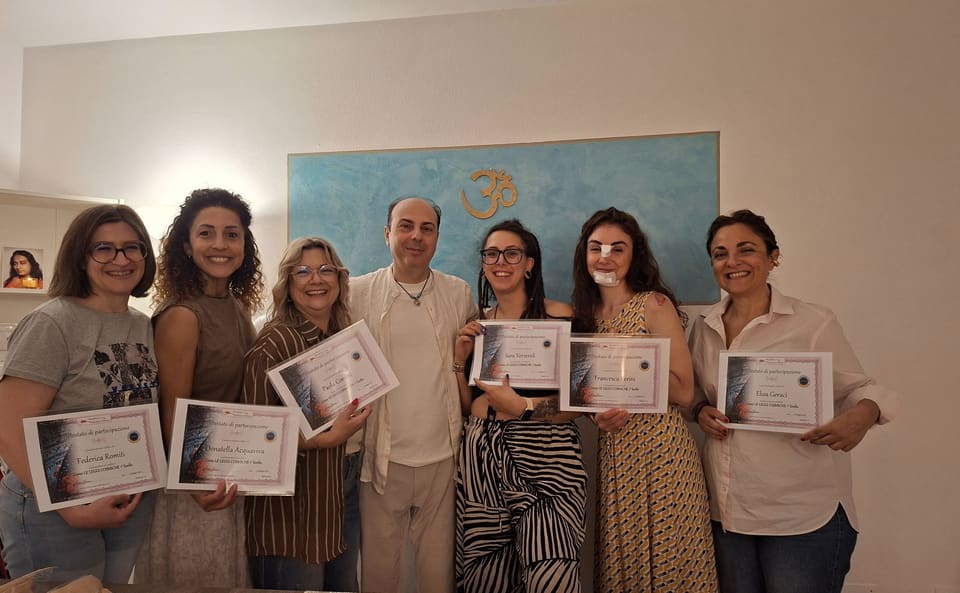 Andrea Barani e un gruppo di partecipanti mostrano gli attestati appena ricevuti, nella sala delle lezioni.